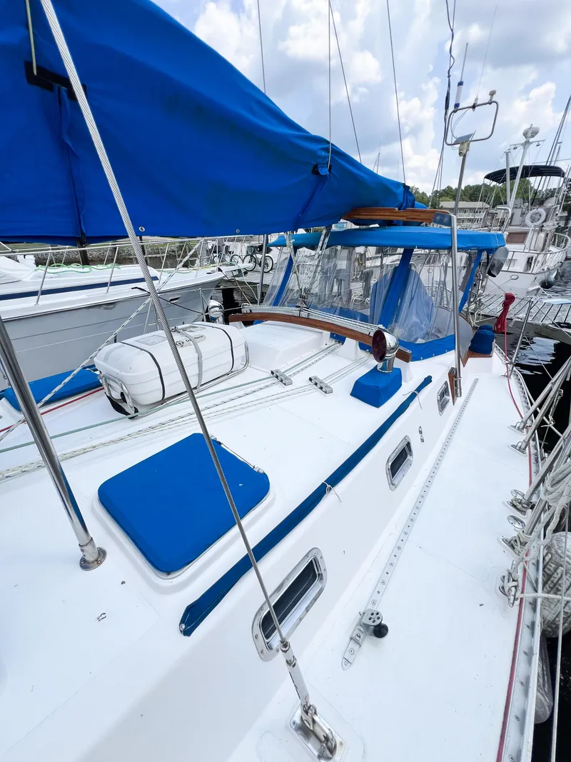 Slide: The Image of 1986 Tayana Vancouver 42 sailboat with blue covers docked at marina. - 10