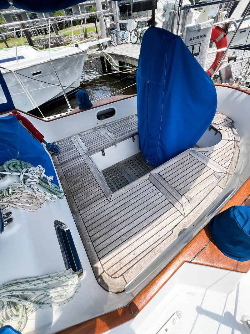 Slide: The Image of Cockpit of 1986 Tayana Vancouver 42 sailboat with teak flooring and blue covers. - 12