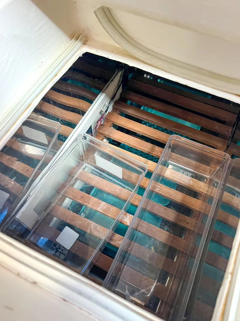 Slide: The Image of Wooden slatted storage area with clear plastic containers on a 1986 Tayana Vancouver 42. - 26