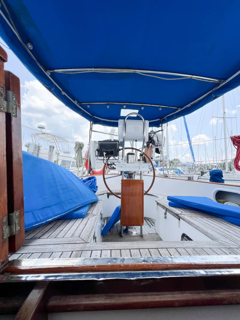 Slide: The Image of 1986 Tayana Vancouver 42 sailboat cockpit with blue canopy and seating, docked at marina. - 30