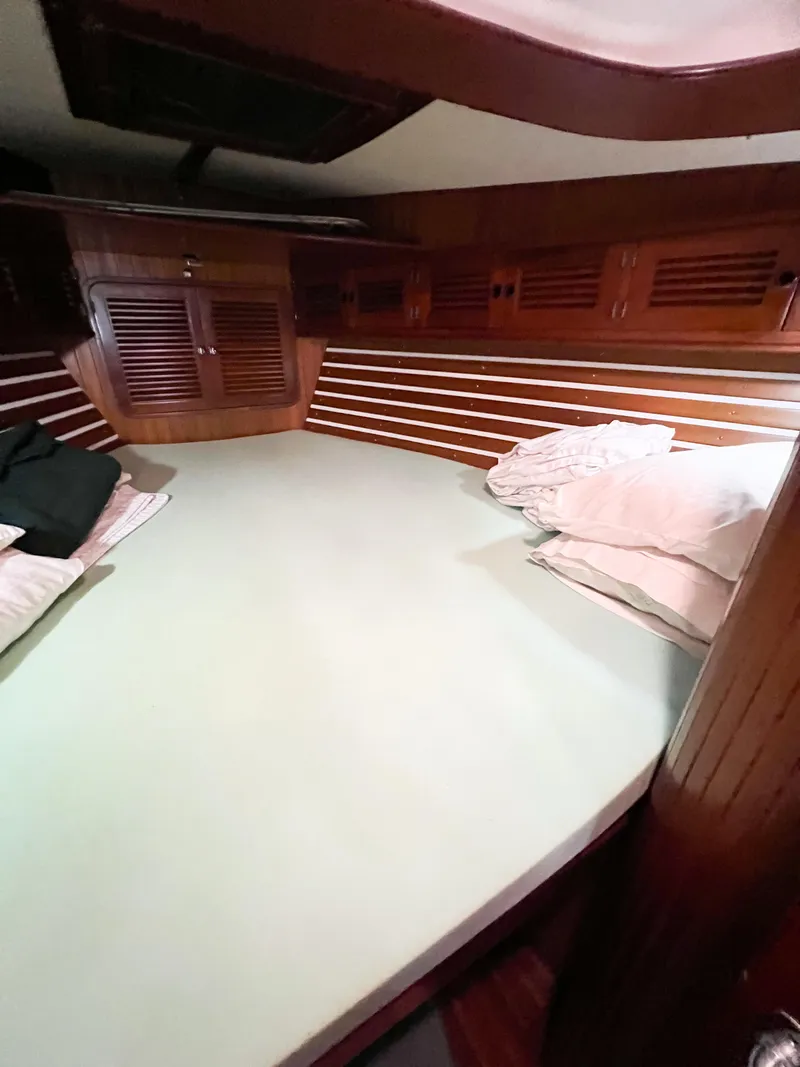Slide: The Image of Cozy cabin interior of 1986 Tayana Vancouver 42 sailboat with wooden paneling and bedding. - 43