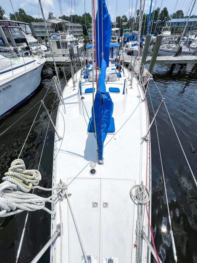 Slide: The Image of 1986 Tayana Vancouver 42 sailboat docked, featuring blue sail covers and a clean white deck. - 6