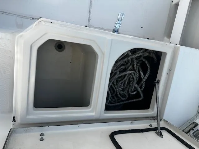 Slide: The Image of Storage compartments on a 1993 Grady-White Sailfish 252 boat, featuring coiled ropes. - 12
