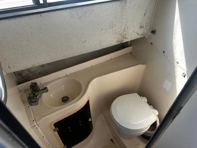 Slide: The Image of 1993 Grady-White Sailfish 252 boat bathroom with sink and toilet. - 16