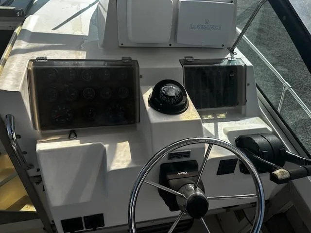 Slide: The Image of 1993 Grady-White Sailfish 252 boat dashboard with steering wheel and navigation instruments. - 6
