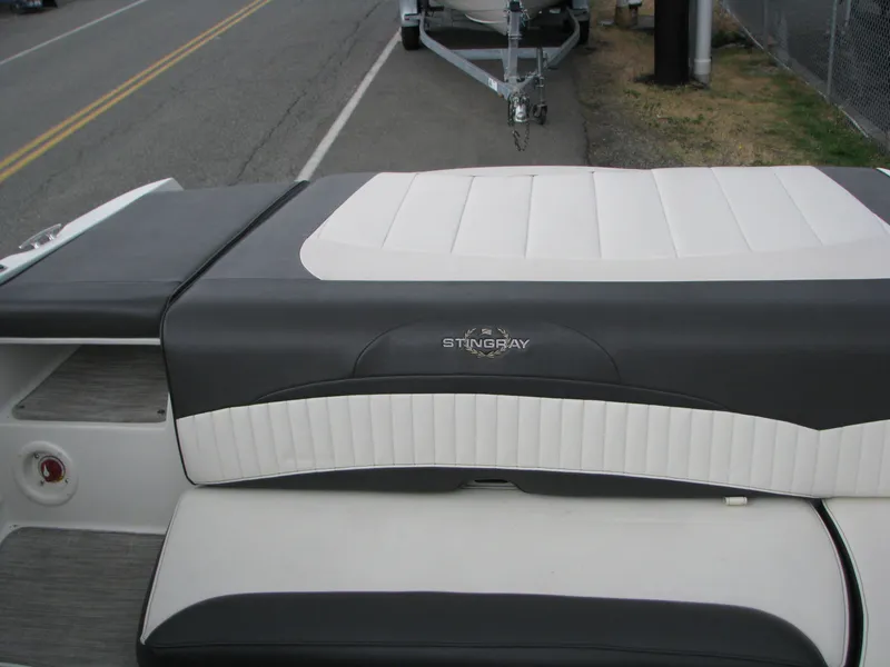 Slide: The Image of 2017 Stingray 215 CR boat with sleek black and white seating on a roadside. - 12