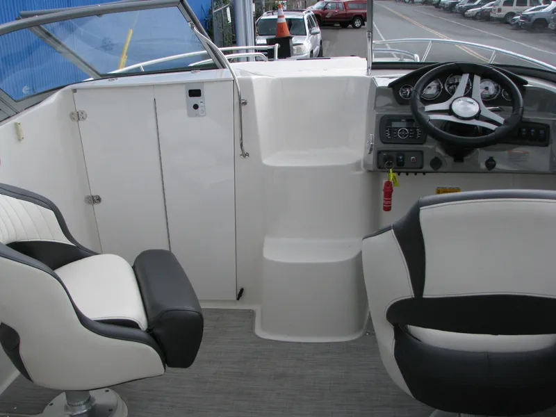 Slide: The Image of Interior of a 2017 Stingray 215 CR boat with steering wheel and seating. - 14