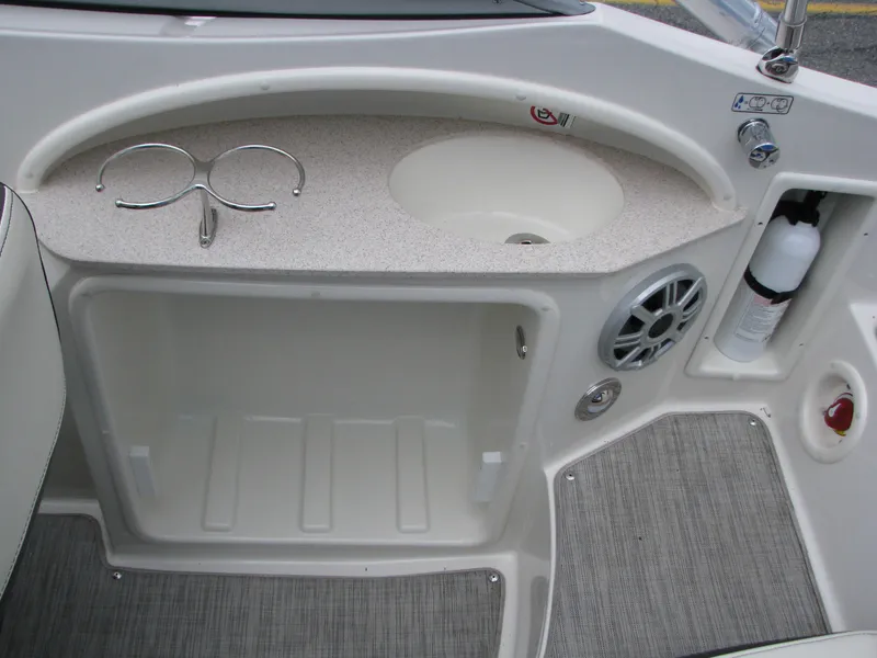 Slide: The Image of 2017 Stingray 215 CR boat interior with sink, storage, and fire extinguisher. - 5