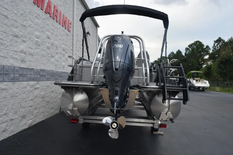 Slide: The Image of 2026 Bentley Pontoons Legacy 223 Swingback with powerful outboard motor, parked outdoors. - 5