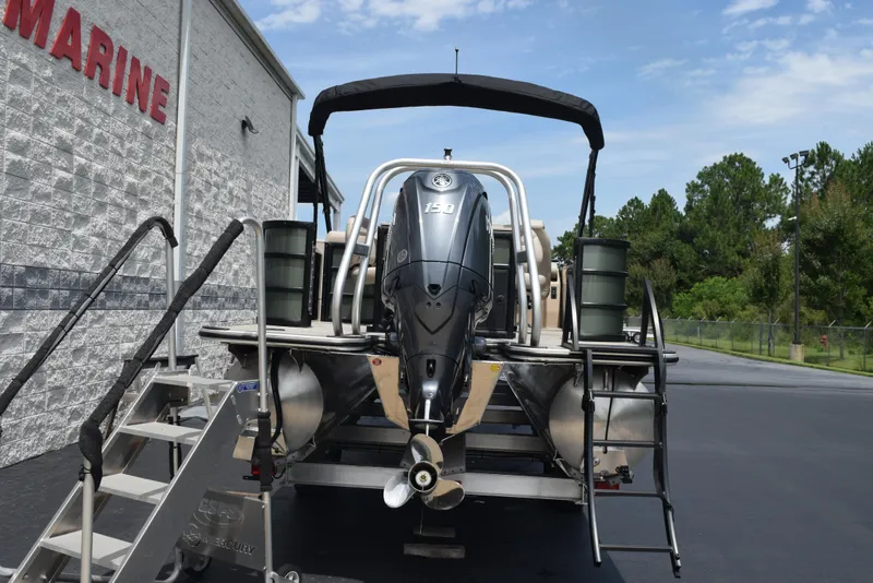 Slide: The Image of 2026 Bentley Pontoons Fish 243 Fish n' Cruise with outboard motor, parked near a marine building. - 4
