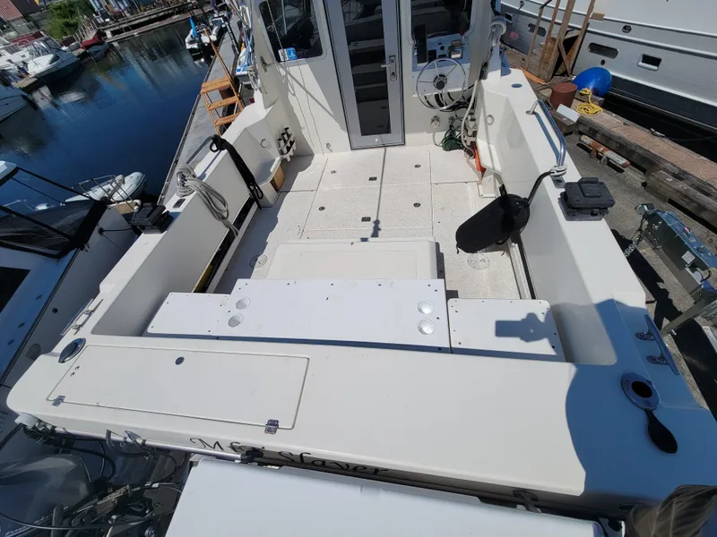 Slide: The Image of 2000 SeaSport 2400 XL Limited boat deck, spacious layout, docked at marina. - 11