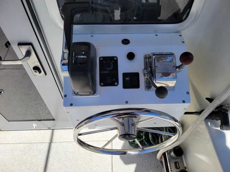 Slide: The Image of Control panel of a 2000 SeaSport 2400 XL Limited boat with steering wheel and throttle. - 16