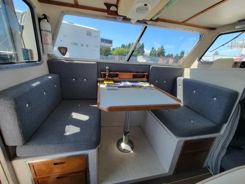 Slide: The Image of Interior of 2000 SeaSport 2400 XL Limited boat with gray seating and wooden table. - 18