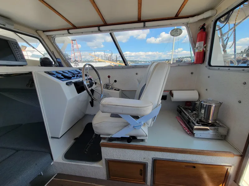 Slide: The Image of Interior of 2000 SeaSport 2400 XL Limited boat with helm, steering wheel, and stove. - 20