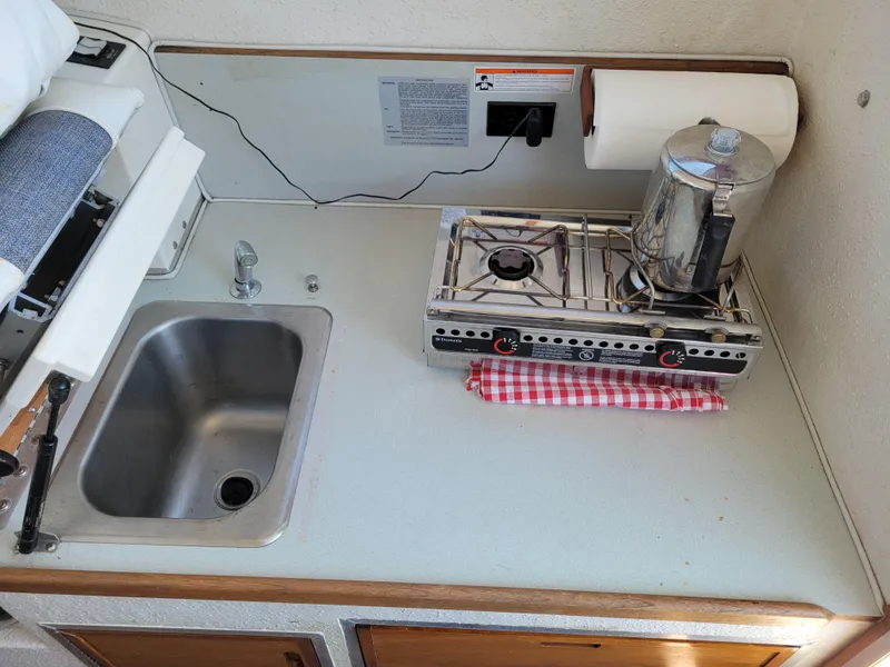 Slide: The Image of Compact boat kitchen with sink, stove, and coffee pot in a 2000 SeaSport 2400 XL Limited. - 21