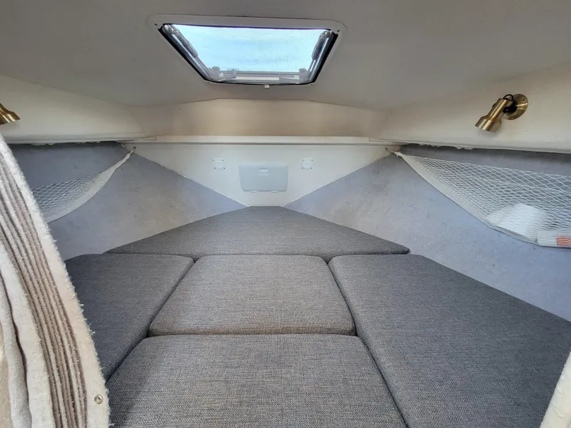 Slide: The Image of Interior cabin of 2000 SeaSport 2400 XL Limited with cushioned seating and overhead hatch. - 22