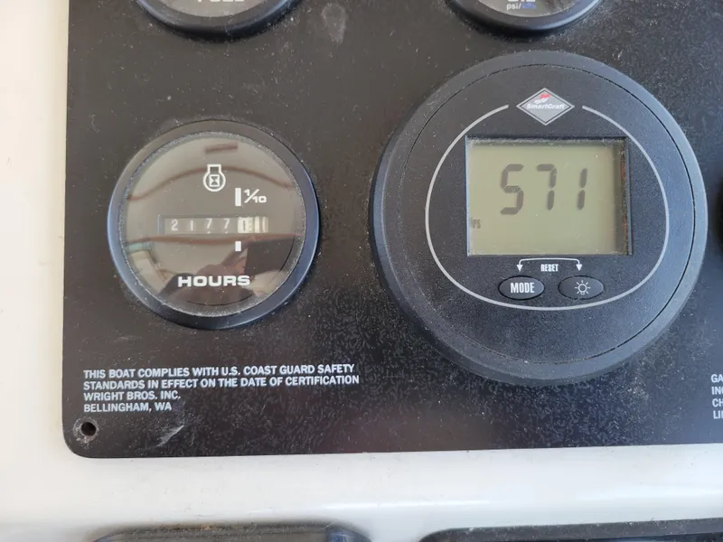 Slide: The Image of Close-up of SeaSport 2400 XL Limited 2000 boat dashboard gauges displaying hours and compliance. - 26