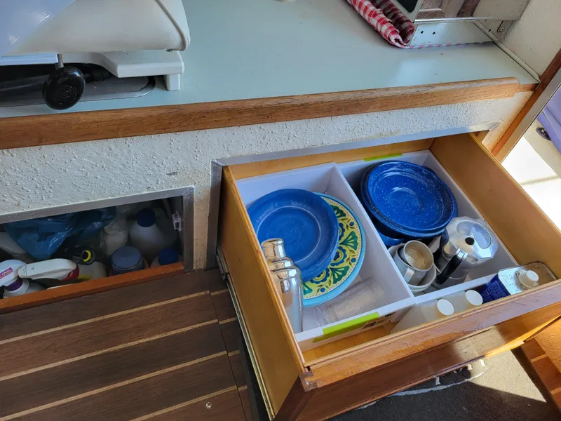 Slide: The Image of Open drawer in 2000 SeaSport 2400 XL Limited boat with plates and kitchen items. - 31