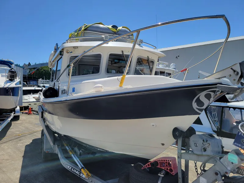 Slide: The Image of 2000 SeaSport 2400 XL Limited boat on trailer, docked under clear blue sky. - 4