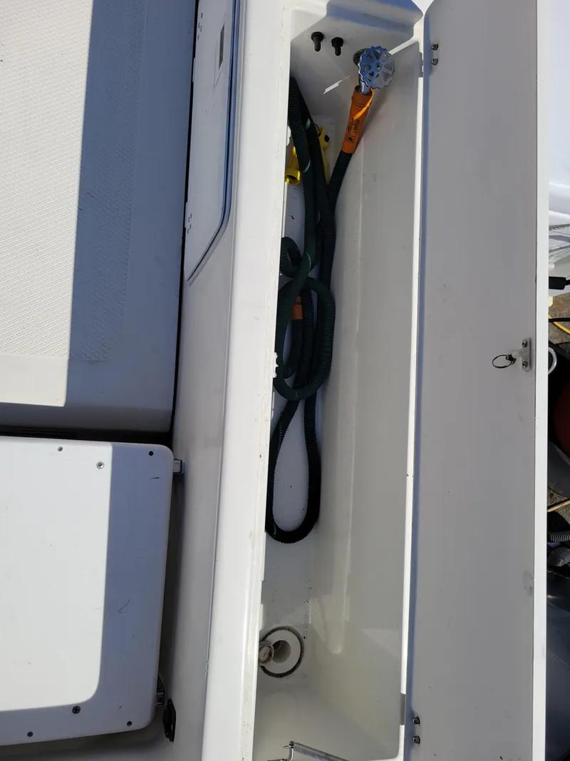Slide: The Image of Storage compartment of a 2000 SeaSport 2400 XL Limited boat with hose and fittings. - 40