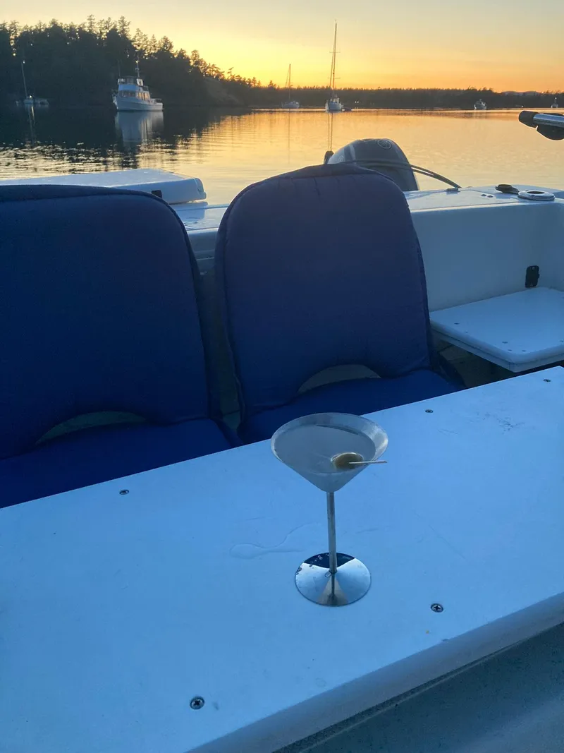 Slide: The Image of Boat interior with blue seats, martini glass, and sunset view on a 2000 SeaSport 2400 XL Limited. - 41