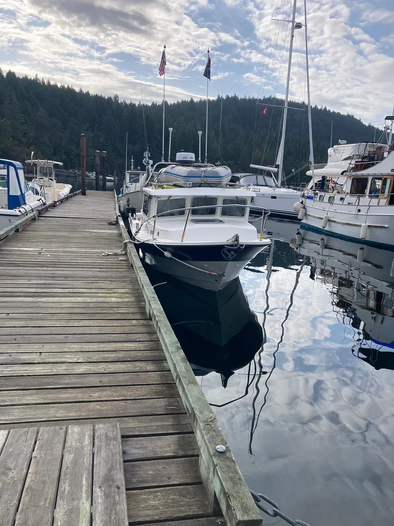 Slide: The Image of Docked 2000 SeaSport 2400 XL Limited boat in a serene marina setting. - 44