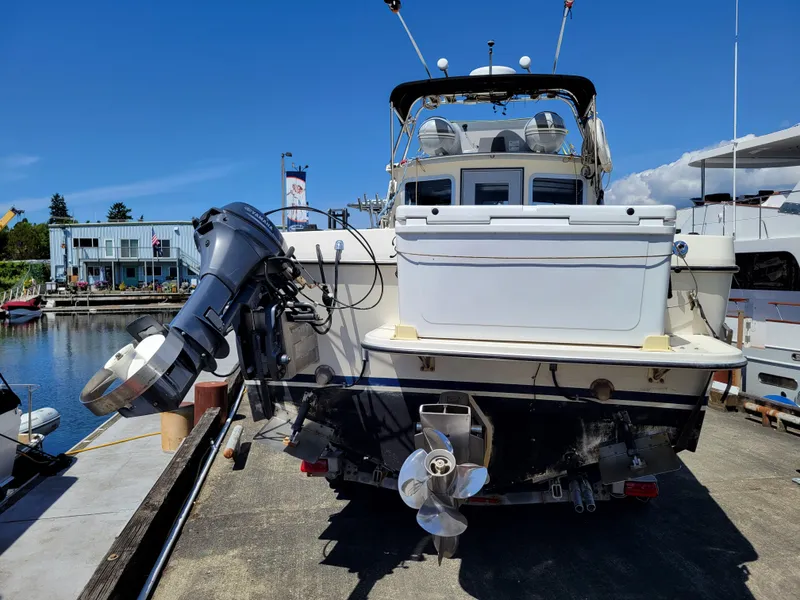 Slide: The Image of 2000 SeaSport 2400 XL Limited boat docked, rear view with outboard motor and propeller. - 7
