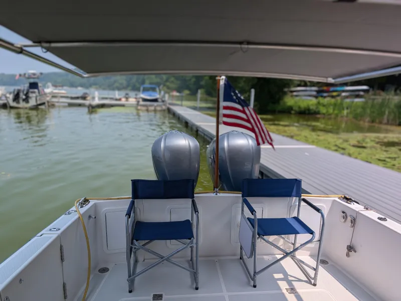 Slide: The Image of 2018 True North 34OE boat docked with chairs and American flag. - 10