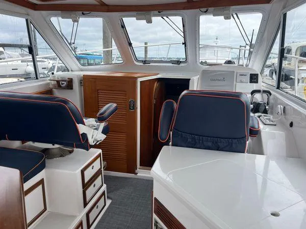 Slide: The Image of Interior of a 2018 True North 34OE boat with blue seating and wooden accents. - 13