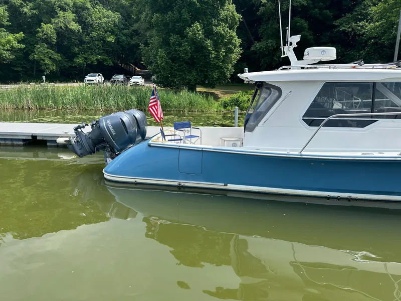 Slide: The Image of 2018 True North 34OE boat docked on calm water with American flag. - 2