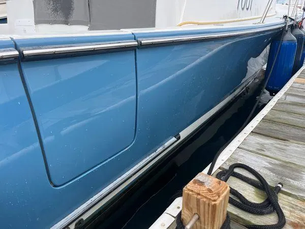 Slide: The Image of 2018 True North 34OE boat docked, blue hull, wooden pier, nautical ropes. - 20