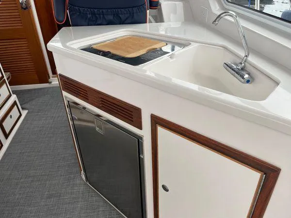 Slide: The Image of Compact kitchen area in a 2018 True North 34OE boat, featuring a sink and cutting board. - 30