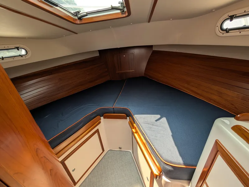 Slide: The Image of 2018 True North 34OE cabin interior with wood paneling and blue bedding. - 35