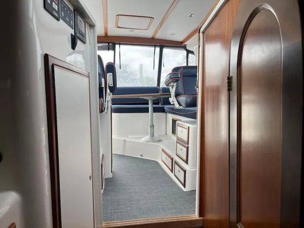 Slide: The Image of Interior of 2018 True North 34OE boat, featuring seating and wooden cabinetry. - 37