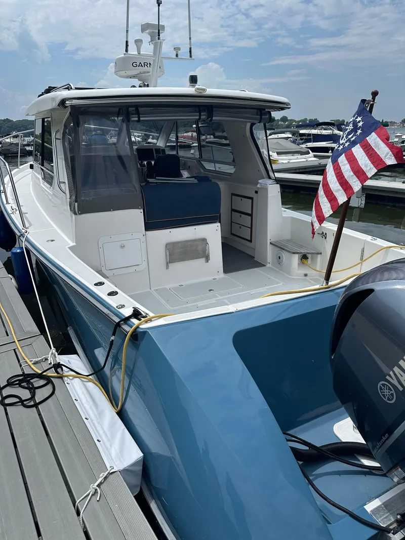 Slide: The Image of 2018 True North 34OE boat docked, featuring blue hull and American flag. - 5