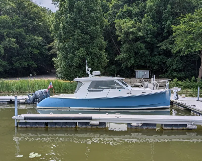 Slide: The Image of 2018 True North 34OE boat docked by lush green trees. - 50