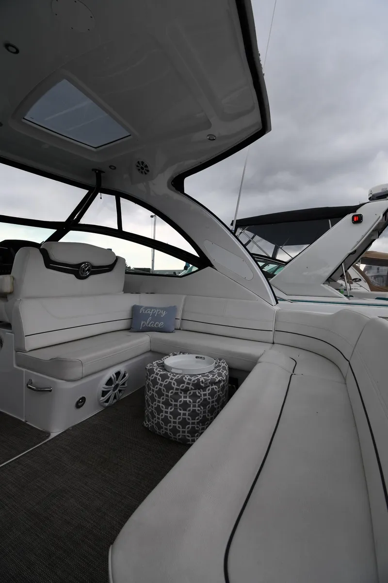 Slide: The Image of 2019 Cruisers Yachts 380 Express interior with plush seating and "happy place" pillow. - 19