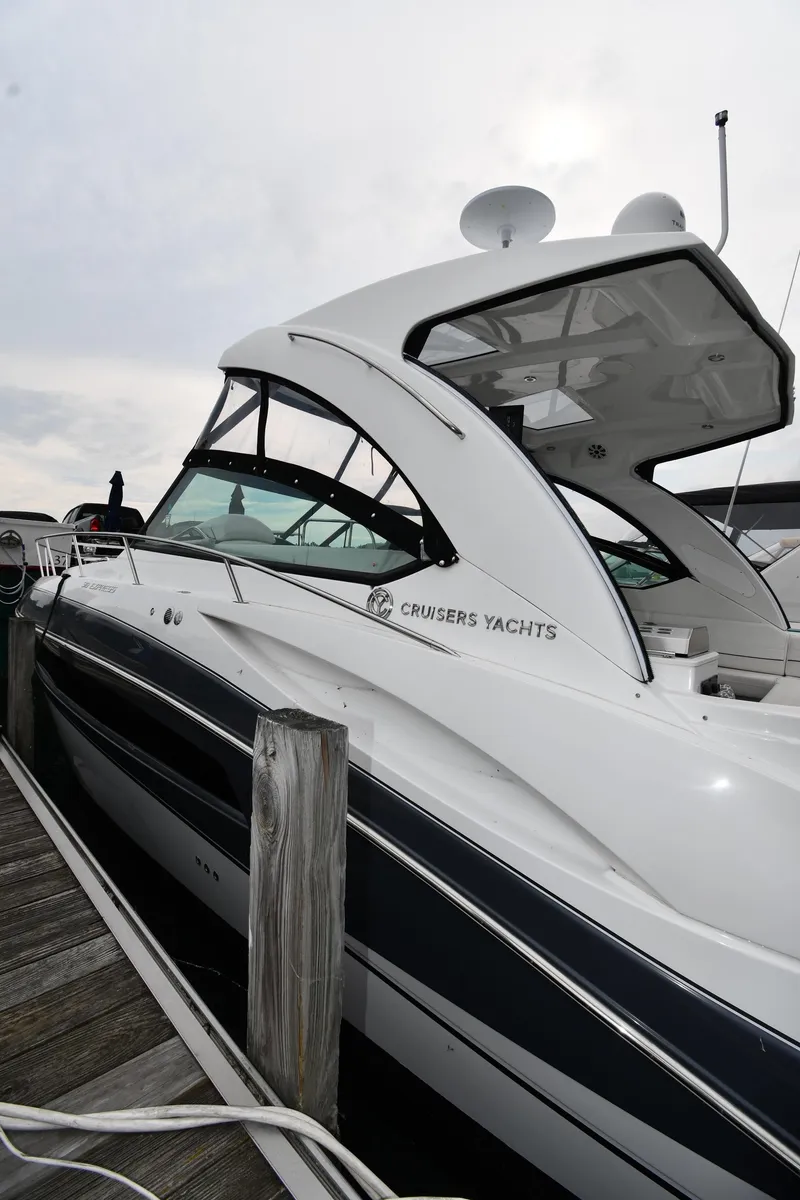 Slide: The Image of 2019 Cruisers Yachts 380 Express docked at marina, side view. - 2