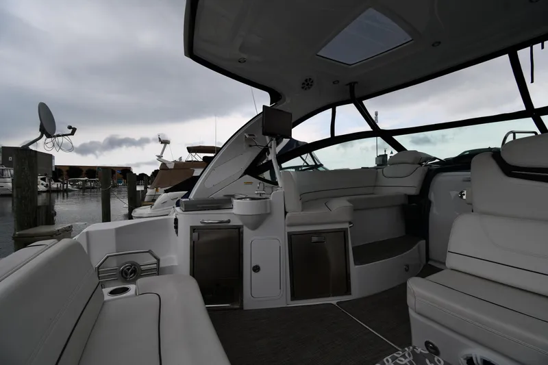 Slide: The Image of 2019 Cruisers Yachts 380 Express interior with sleek seating and modern amenities at a marina. - 20