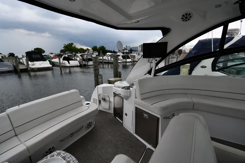 Slide: The Image of 2019 Cruisers Yachts 380 Express interior with seating, docked at marina. - 22
