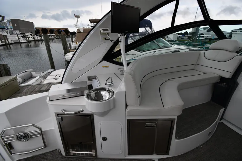 Slide: The Image of 2019 Cruisers Yachts 380 Express interior with seating, sink, and dock view. - 23