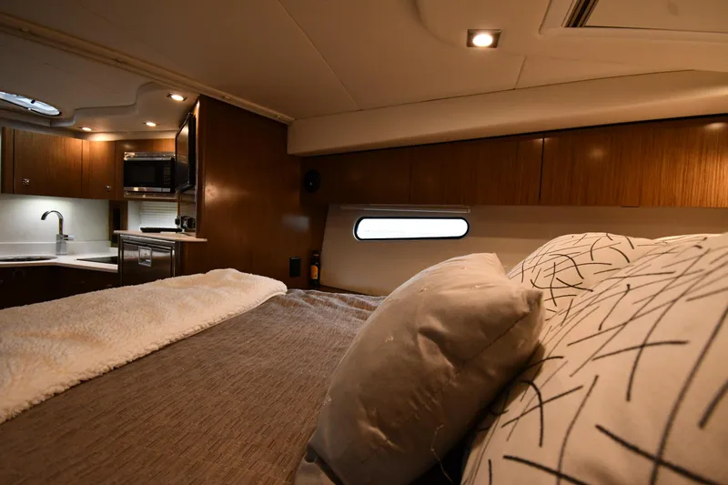 Slide: The Image of Luxurious interior of 2019 Cruisers Yachts 380 Express with cozy bedding and modern kitchen amenities. - 35