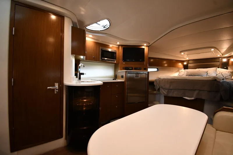 Slide: The Image of 2019 Cruisers Yachts 380 Express interior with kitchenette, bed, and seating area. - 39
