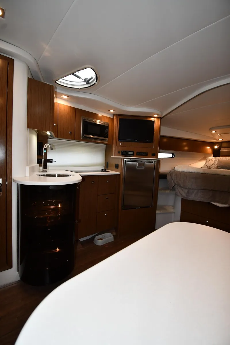 Slide: The Image of 2019 Cruisers Yachts 380 Express interior with modern kitchen and cozy sleeping area. - 40