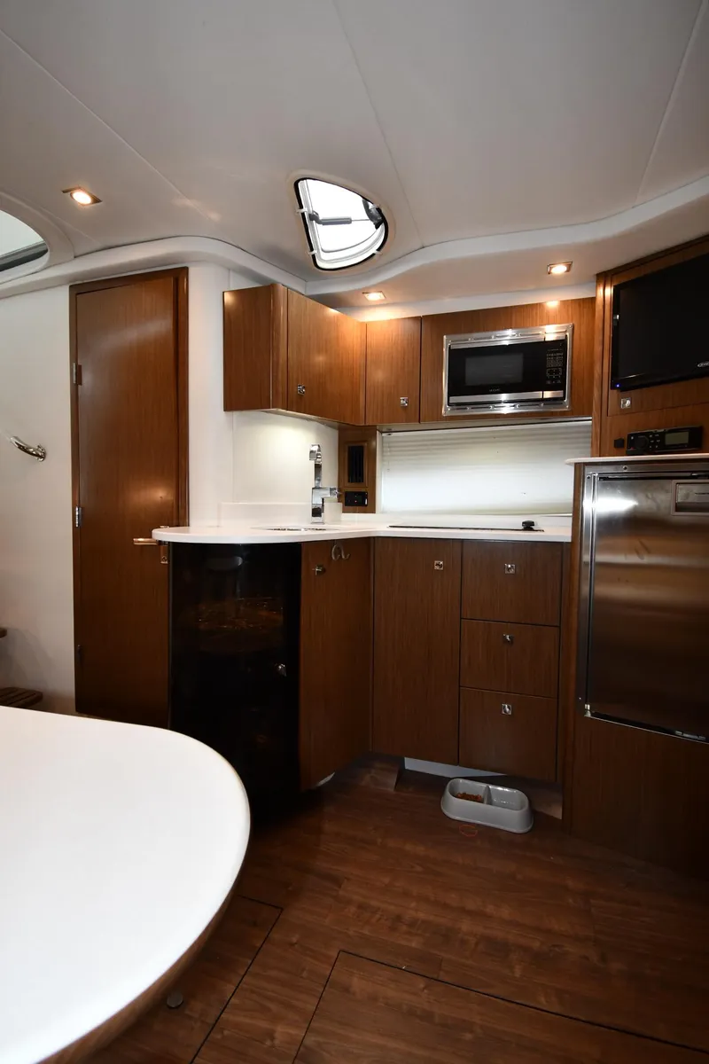 Slide: The Image of 2019 Cruisers Yachts 380 Express interior kitchen with wood cabinetry and modern appliances. - 41