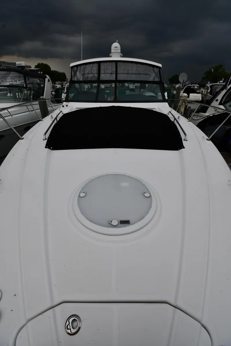 Slide: The Image of 2019 Cruisers Yachts 380 Express under stormy skies at a marina. - 7