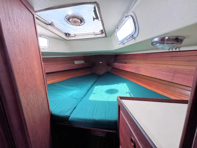 Slide: The Image of 1986 Sabre 34 MK II sailboat cabin with teal bedding and wooden interior. - 15