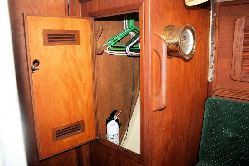 Slide: The Image of Wooden closet interior on 1986 Sabre 34 MK II yacht with hangers and fire extinguisher. - 19