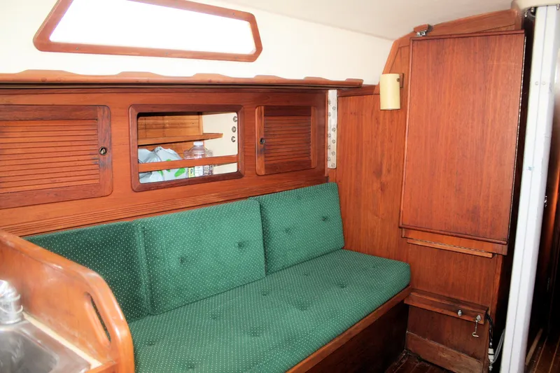 Slide: The Image of Interior of 1986 Sabre 34 MK II sailboat with green cushioned seating and wooden cabinetry. - 24