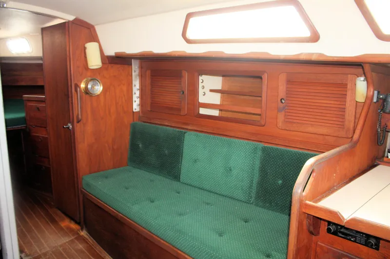 Slide: The Image of Interior of 1986 Sabre 34 MK II sailboat with green cushioned seating and wooden cabinetry. - 25